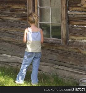 Girl standing by window