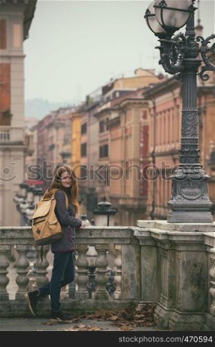 girl standing near parapet and looking at the camera, Bologna. italy