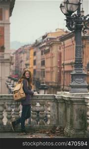 girl standing near parapet and looking at the camera, Bologna. italy