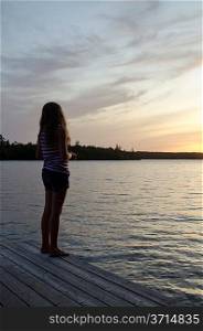 Girl standing on a boardwalk, Lake of the Woods, Ontario, Canada