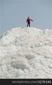 Girl standing on a pile of snow at Winnipeg Beach, Manitoba, Canada