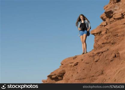 Girl standing on cliff at coast, Green Gables, Cavendish, Prince Edward Island, Canada