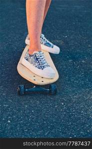 Girl standing on longboard with bruise on her lower leg, copyspace. Girl standing on longboard with bruise on her lower leg