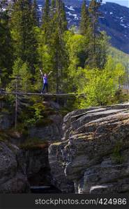 girl standing on suspension bridge. Canyon View at tre world famous waterfall Rjukandefossen, Norway