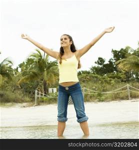 Girl standing on the beach with her arms outstretched