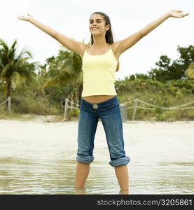 Girl standing on the beach with her arms outstretched