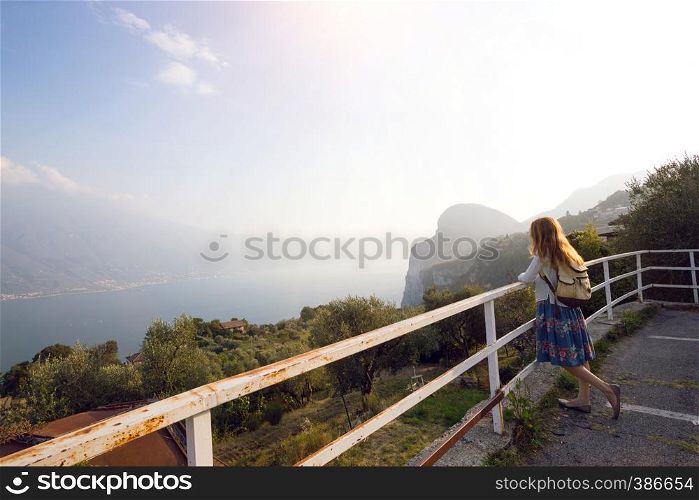 girl standing on the viewing platform and look at the lake Garda. Italy