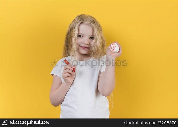girl standing with painted egg felt pen