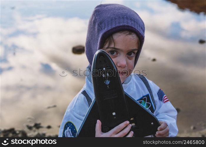 girl standing with spaceship toy