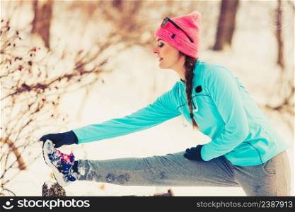 Girl stretching on bench in winter. Sports fitness fashion concept. Girl stretching on bench in winter