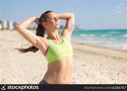 Girl stretching on the beach after a workout