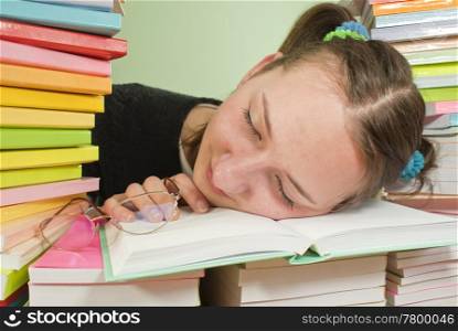 Girl student sleeping on the stack of books