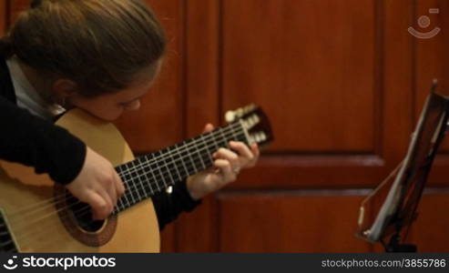 girl studies to play a guitar.