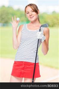 Girl successful golfer posing with props for playing on a background of golf courses