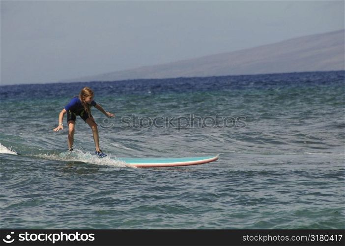 Girl surfing in Maui