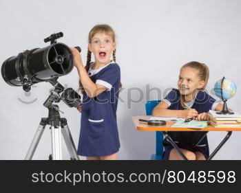 Girl surprised astronomer observing through a telescope, the other girl looked at her