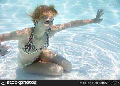 Girl swimming underwater in a swimming pool
