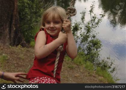 Girl swinging on a rope swing
