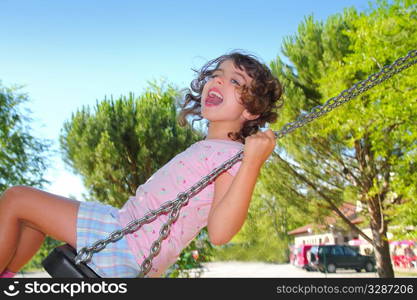 Girl swinging swing in outdoor park nature low angle view