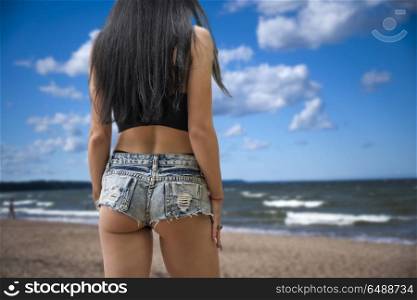 girl takes off shorts on the beach at sunset. girl takes off shorts on the beach