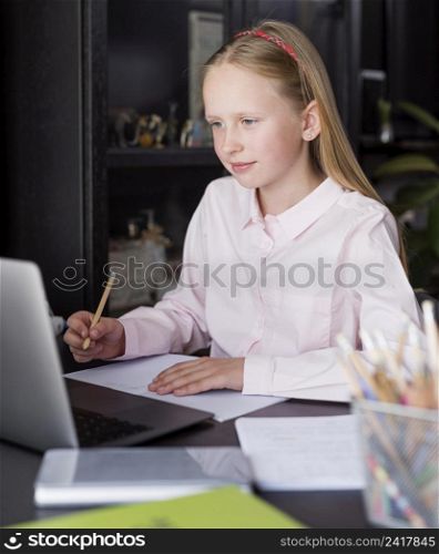 girl taking notes online class