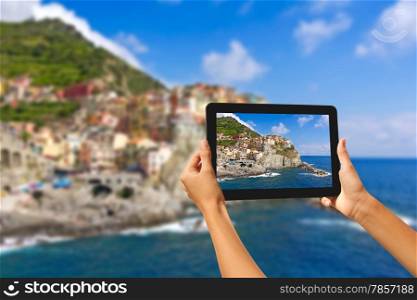 Girl taking pictures on a tablet in Manorola, Cinque Terre, Italy
