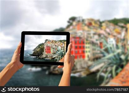 Girl taking pictures on a tablet in Riomaggiore, Cinque Terre, Italy