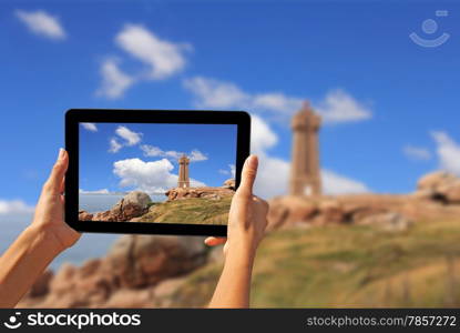 Girl taking pictures on a tablet Pors Kamor lighthouse, Ploumanac&rsquo;h, Brittany, France&#xA;