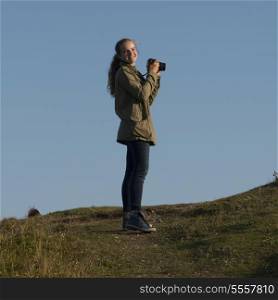 Girl taking pictures with camera, Skerwink Trail, Port Rexton, Bonavista Peninsula, Newfoundland And Labrador, Canada