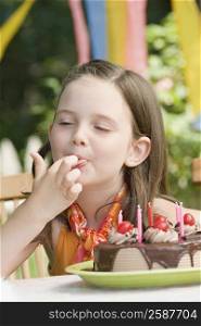 Girl tasting a birthday cake