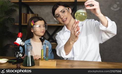 girl teacher doing science experiments with microscope