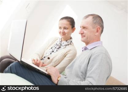 Girl teaching to use a laptop by senior man