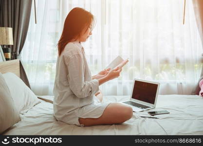 Girl teen read a book self education or working at home during covid self quarantine. women reading a book at bed in the morning.