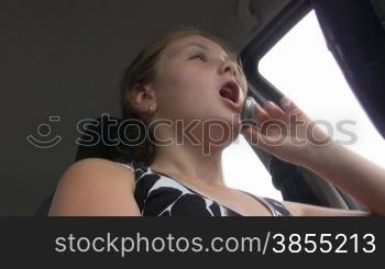 girl-teenager at wheel car speaks on phone.