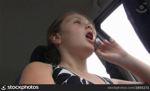 girl-teenager at wheel car speaks on phone.