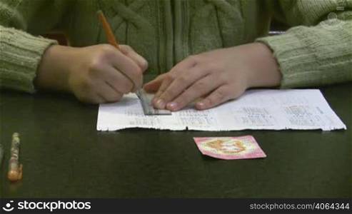 girl - teenager draws behind a table.