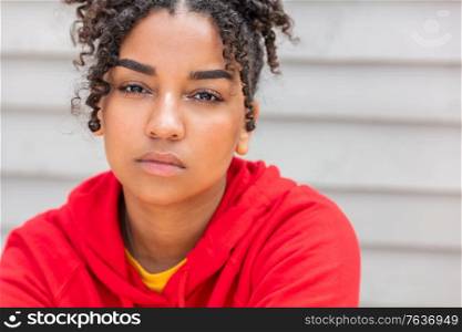 Girl teenager teen female young African American mixed race biracial woman outside looking thoughtful and wearing red hoodie