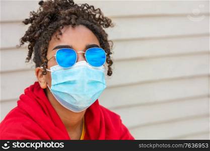 Girl teenager teen mixed race biracial African American female young woman wearing blue sunglasses and face mask in Coronavirus COVID-19 pandemic