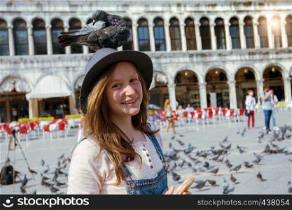 Girl teenager with dove on Piazza San Marco, venice. Italy