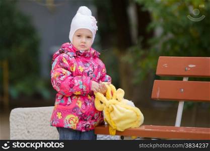 Girl three years walking on the Playground in cool autumn weather