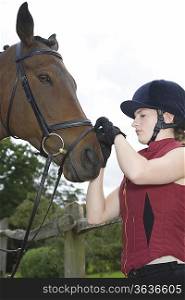 Girl tightening horse&acute;s bridle