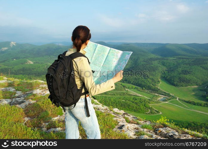 Girl tourist in mountain read the map.