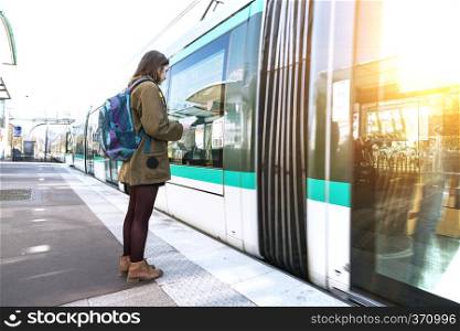 girl tourist with a backpack stands on the platform and waits for the train in Paris. France