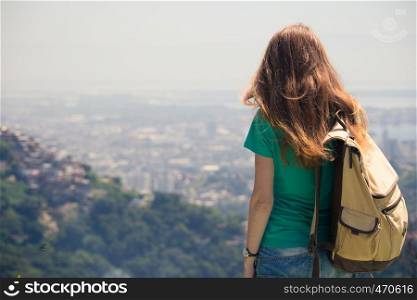 girl tourist with backpack looking at the Rio cityscape