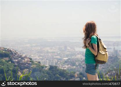 girl tourist with backpack looking at the Rio cityscape