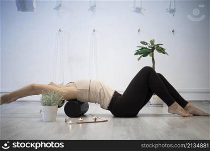 girl training in yoga studio. Healthy and Yoga Concept. girl is engaged on a yoga roller