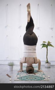 girl training in yoga studio. Healthy and Yoga Concept. girl doing headstand