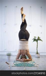 girl training in yoga studio. Healthy and Yoga Concept. girl doing headstand