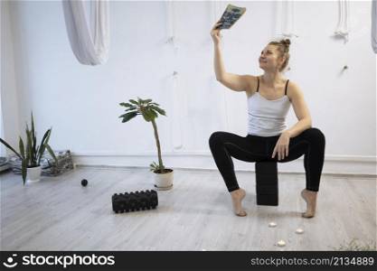 girl training in yoga studio. Healthy and Yoga Concept. happy smiling girl read book