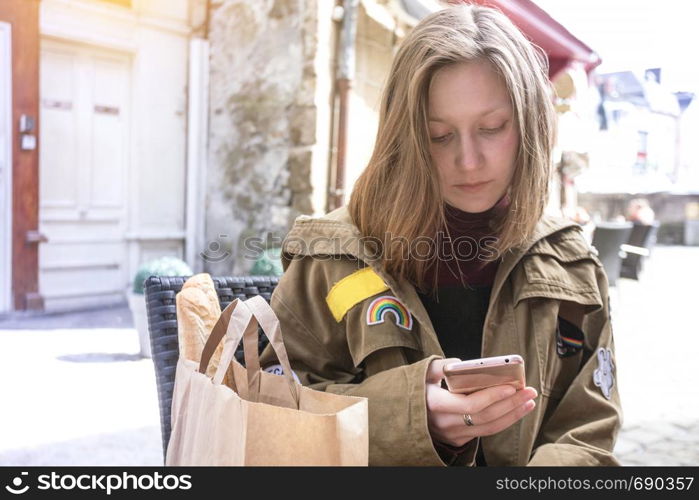 girl traveler sits in a cafe with a smartphone. Morlaix, France